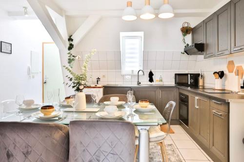 une cuisine avec une table et des chaises dans une pièce dans l'établissement Le CLOONEY - appartement en duplex - Hyper centre, à Mulhouse