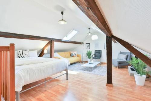 un salon avec un lit et un canapé dans l'établissement Le CLOONEY - appartement en duplex - Hyper centre, à Mulhouse