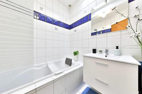 une salle de bain blanche avec une baignoire et un lavabo dans l'établissement Le CLOONEY - appartement en duplex - Hyper centre, à Mulhouse