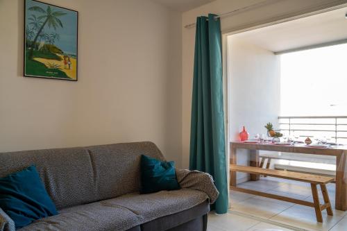 a living room with a couch and a table at Évasion Saint-Leu in Saint-Leu