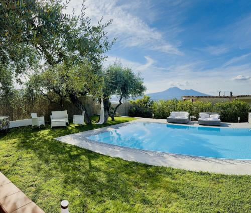 a swimming pool in a yard with two lawn chairs at Villa C Luxury Estate in SantʼAntonio Abate