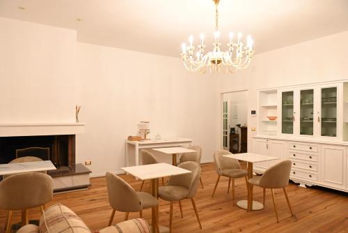 a dining room with tables and chairs and a chandelier at Casa FEREMI in Cavallino di Lecce