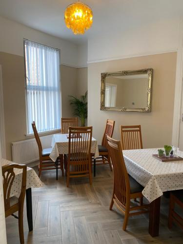 a dining room with tables and chairs and a mirror at Roskeen Townhouse in Belfast