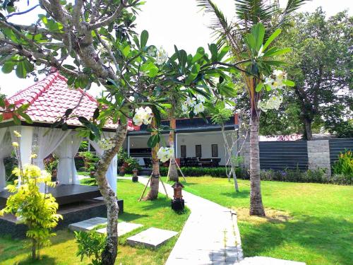 a yard with trees and a house with a fire hydrant at D'Mell Bali in Nusa Dua