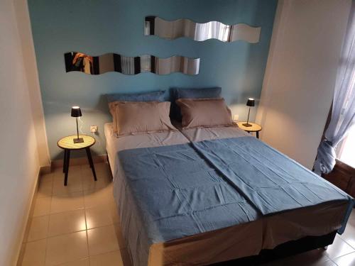 a bedroom with a large bed and two tables at Alas Maisonette in Pefkohori