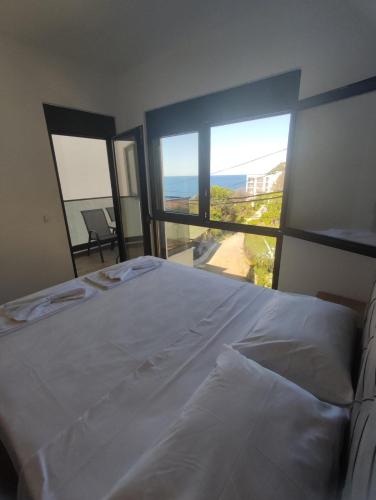 a bedroom with a bed and a view of the ocean at SD LUX APARTMENTS in Dobra Voda