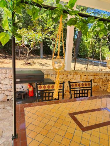 a swing hanging from a tree with two benches at Domus Valentina in Selva di Fasano