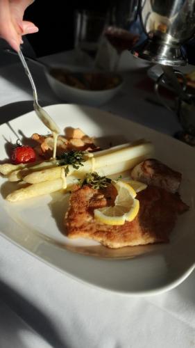 a white plate with food on a table at Hotel Restaurant Rebstock in Oppenau