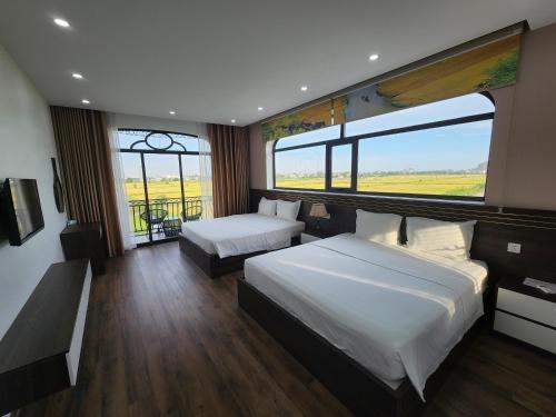 a hotel room with two beds and a large window at Lotus Hotel Ninh Bình in Ninh Binh