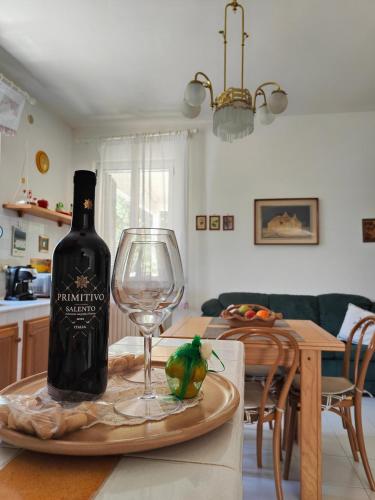 a bottle of wine and a wine glass on a table at Domus Valentina in Selva di Fasano