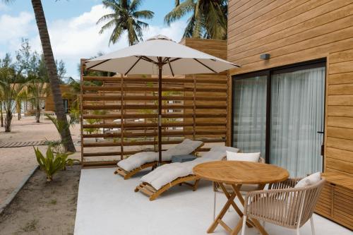 a patio with a table and an umbrella at Sentidos Beach Retreat in Miramar