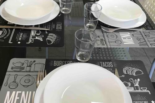 a table with a white plate and glasses on it at Hollywood Apartment in Bragança