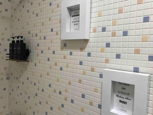 a tiled bathroom with two signs on the wall at Hollywood Apartment in Bragança