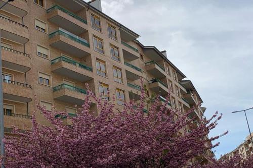 a tall building with purple flowers in front of it at Hollywood Apartment in Bragança