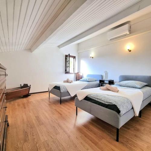 Cette chambre spacieuse dispose de 2 lits et de parquet. dans l'établissement Villa l'Olivier en Provence 5ch piscine jardin et clim, à Lambesc