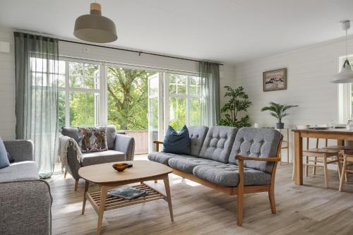 a living room with a couch and chairs and a table at Lakeview spacious family home in Trollhättan