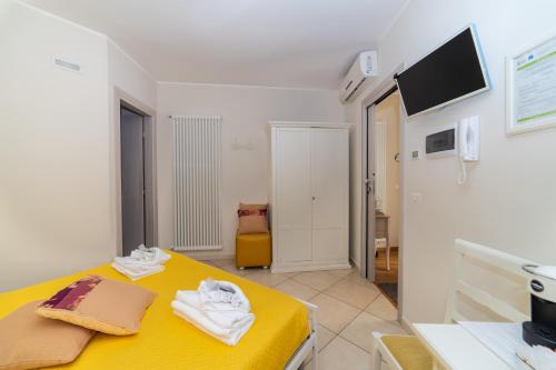 a room with a yellow bed and a tv at Santa Sofia Affittacamere in Gravina in Puglia