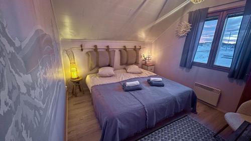 a bedroom with a bed with two towels on it at Jokimaja BoutiqueHotel in Köngäs