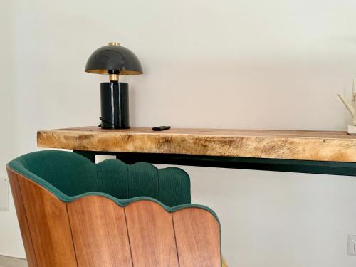 a desk with a lamp and a green chair at Anno13Suites in Naples