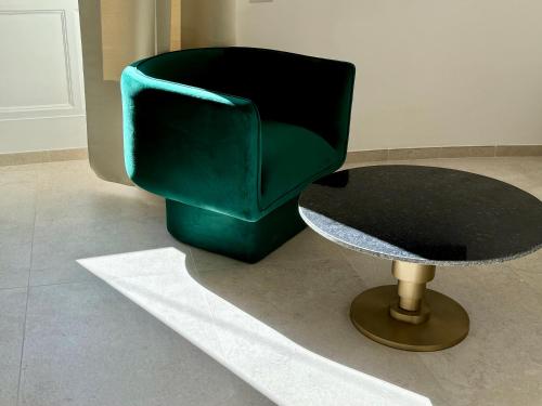 a green chair and a table in a room at Anno13Suites in Naples