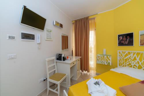 a room with two beds and a desk and a television at Santa Sofia Affittacamere in Gravina in Puglia