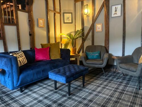 a living room with a blue couch and two chairs at Aleppo Merchant Inn in Carno