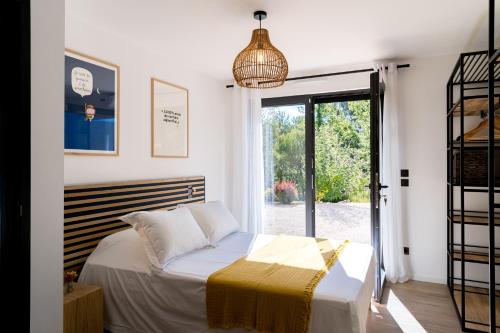 une chambre avec un lit et une grande fenêtre dans l'établissement Les Roches Blanches-Montferrat, à Montferrat