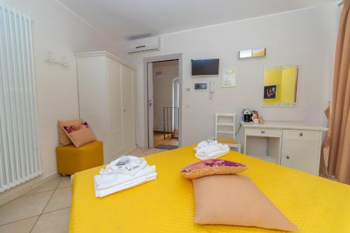 a room with a yellow table with towels on it at Santa Sofia Affittacamere in Gravina in Puglia