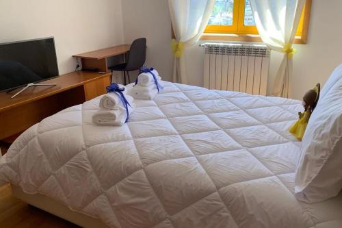 a bedroom with a large white bed with towels on it at Hollywood Apartment in Bragança