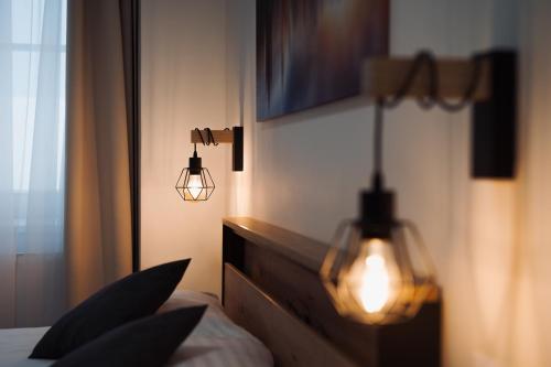 a bedroom with a bed with two lights on it at Prague Old Town Liliova Garden in Prague