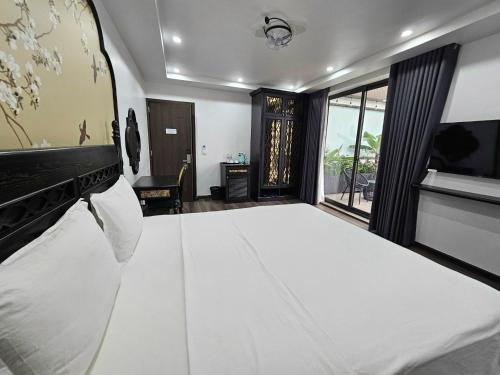 a bedroom with a large white bed and a window at Lotus Hotel Ninh Bình in Ninh Binh