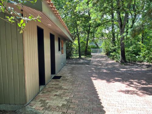 a brick walkway next to a building with trees at L'Ecrin sous les Chênes in Gradignan