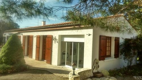 une maison blanche avec une grande porte en verre dans l'établissement Villa de vacances bord de mer, à Meschers-sur-Gironde
