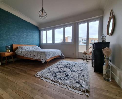 une chambre avec un lit, un tapis et une fenêtre dans l'établissement Appartement Dunkerque Centre Théâtre, à Dunkerque