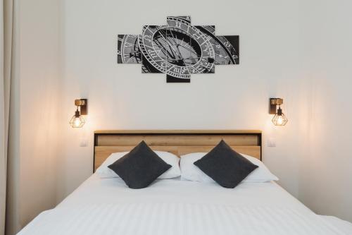a bedroom with a bed with a clock on the wall at Prague Old Town Liliova Garden in Prague