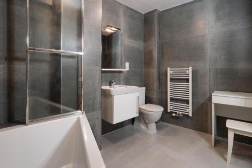 a bathroom with a toilet and a sink and a bath tub at Prague Old Town Liliova Garden in Prague