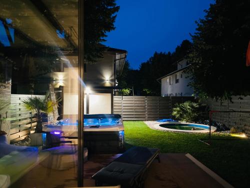 a backyard with a jacuzzi in the yard at night at PS36 Holiday Home Siófok in Siófok