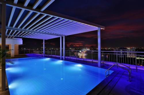 a swimming pool on the roof of a building at night at Olive Downtown in Cochin