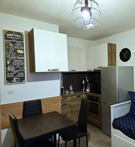 Il comprend une cuisine équipée d'une table et d'un réfrigérateur. dans l'établissement 