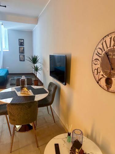 ein Wohnzimmer mit einer großen Uhr an der Wand in der Unterkunft Residenza Elegante - A 5 fermate dal Duomo in Mailand