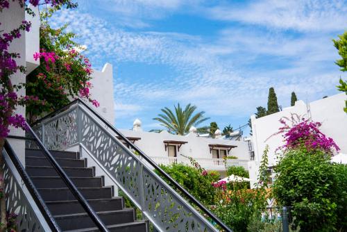 a staircase leading up to a white house with flowers at Manuela Boutique Hotel Bitez in Bitez