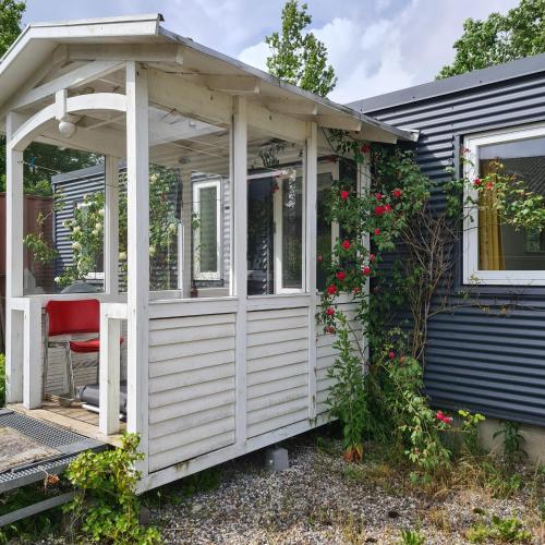 a white pergola on the front of a house at Tiny house i nærheden af Egeskov Slot in Kværndrup