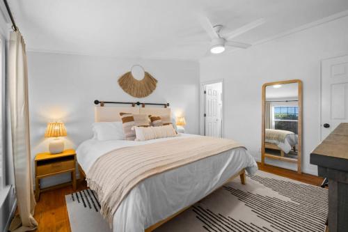 a white bedroom with a large bed and a mirror at Leisure Escape - TX Hill Country in Dripping Springs