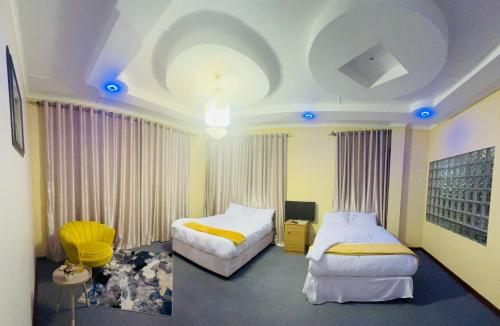 een slaapkamer met 2 bedden en een kamer met blauwe verlichting bij GoldenWays Motel in Mbabane