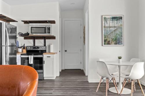 a white kitchen with a table and chairs at Leisure Escape - TX Hill Country in Dripping Springs