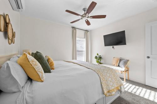 a white bedroom with a bed and a ceiling fan at Leisure Escape - TX Hill Country in Dripping Springs
