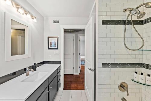 a white bathroom with two sinks and a shower at Mid-century home in Zilker with a backyard in Austin