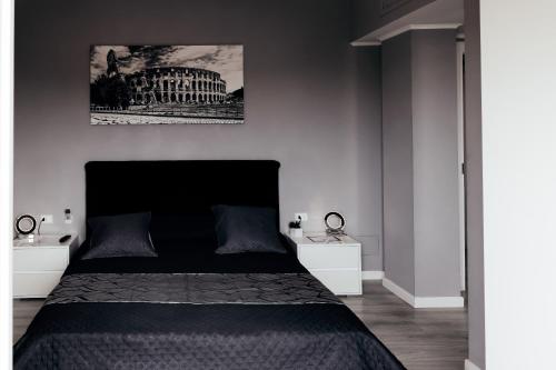 a bedroom with a black bed and two night stands at Villa Erasi in Fiumicino