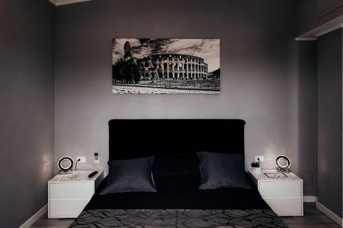 a bedroom with a bed with two night stands and a picture of a building at Villa Erasi in Fiumicino