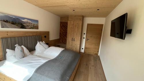 a bedroom with a bed and a flat screen tv at Quartier Severin in Berwang